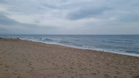 Dynamic waves rolling onto sandy beach under cloudy autumn coastal sky Stock Footage 321651082