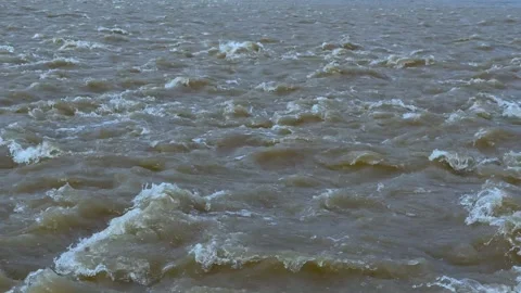 Dynamic waves in a turbulent sea with frothy whitecaps under a cloudy sky o.. Stock Footage 339296659