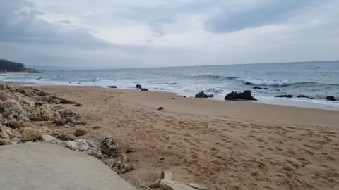 Dynamic waves washing rocky sandy beach under cloudy coastal autumn sky Stock Footage 321651080