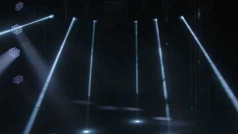 Dynamic white beams of stage light on black studio background. The searchlight Stock-Footage 148410987