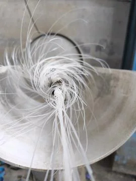 Dynamic White Plastic Strands Spiraling in an Industrial Machine Stock Photos