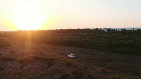 Dynamic wide aerial shot of all-terrain SUV with a rooftop tent riding Stock Footage 231454161