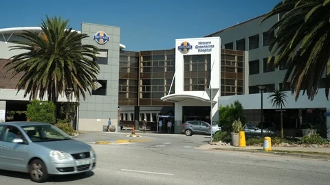 Dynamic wrap around Netcare Greenacres Hospital, pedestrians and vehicle traffic Stock Footage 126127997