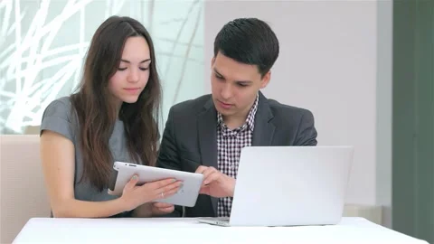 Dynamic young business duo collaborating on data analysis with a tablet Stock Footage 311807389
