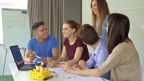 Dynamic young professionals collaborating over a laptop in a modern office Video stock 311983927