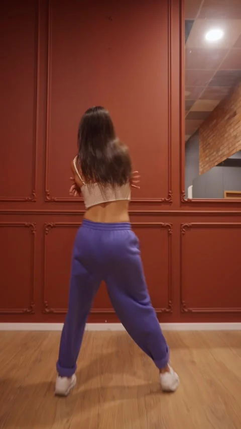 Dynamic young woman performs a fast freestyle dance with energetic turns. Stock Footage 312514993