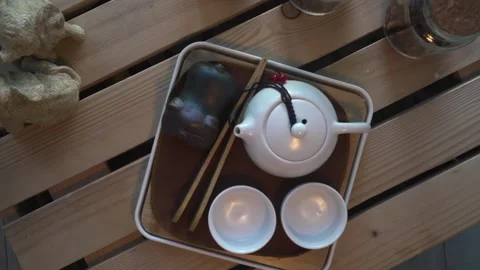 Dynamic zoom and twist shot of an elegant white Chinese tea set and pig tea pet. Stock Footage 303606402