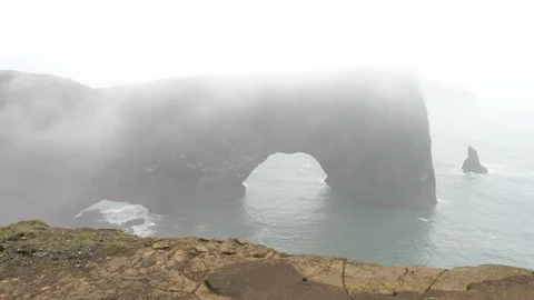 Dyrholaey stone arch under heavy fog Stock Footage 112390948