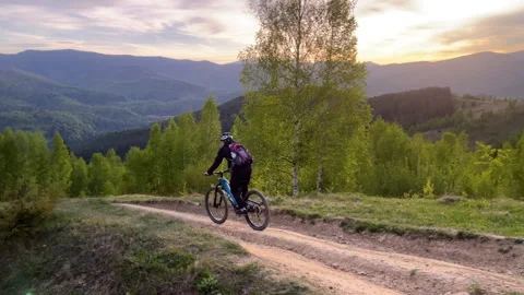 E-bike cyclist advances through wild Carpathian hillside and forest path in Stock Footage 346725618
