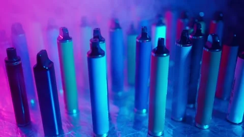 E-Cigarettes and Vapes with Smoke in Neon Lighting. Concept of Bad Habits.
