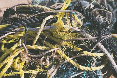 E Close multi colored black white yellow green old fishing twisted cotton ropes Stock Photos