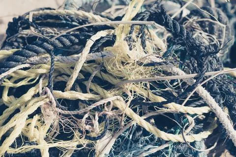E Close multi colored black white yellow old fishing twisted cotton ropes heap Stock Photos