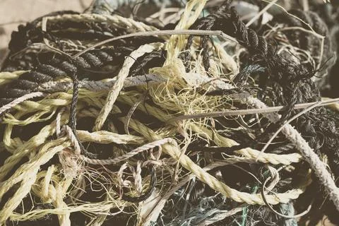 E Close multi colored black white yellow old fishing twisted cotton ropes heap Stock Photos