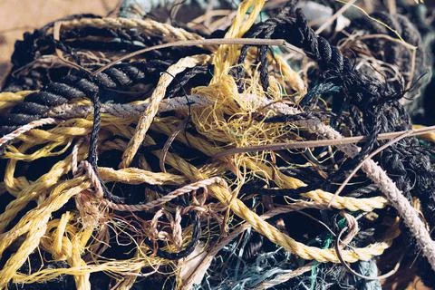 E Close multi colored black white yellow green old fishing twisted cotton ropes Stock Photos