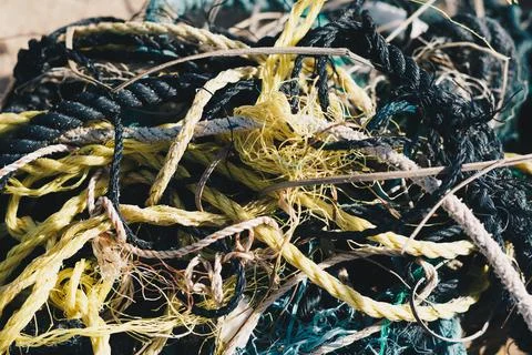 E Close multi colored black white yellow green old fishing twisted cotton ropes Stock Photos