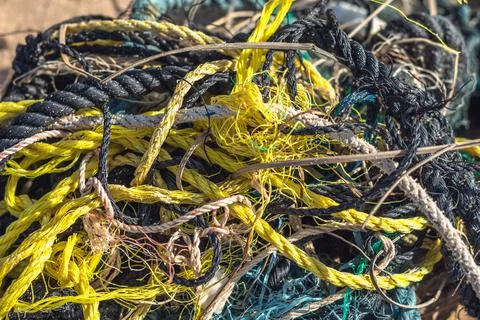 E Close multi colored black white yellow green old fishing twisted cotton ropes Stock Photos