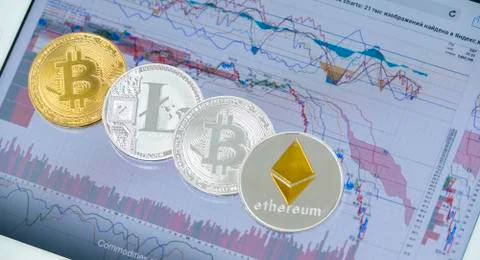 E-coins on tablet computer with charts on screen Stock Photos