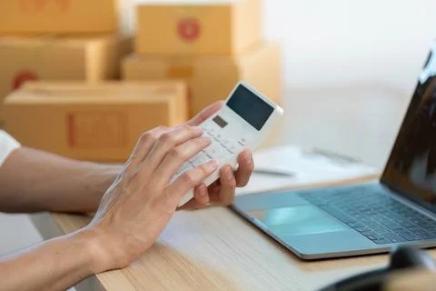 E-commerce entrepreneur using smartphone for order management at home office Stockfoto's