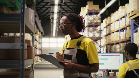 E-commerce female employee checking parcel details on clipboard Video stock 315541222