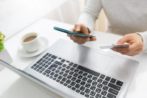 E-commerce. Using a phone and a credit card to buy and pay in an online store.  Stock Photos