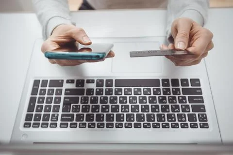  E-commerce. Using a phone and a credit card to buy and pay in an online store.  Stock Photos