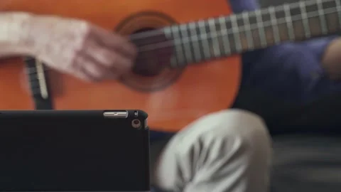 E-learning concept. Tablet with person playing guitar in the background Stock Footage 201360767