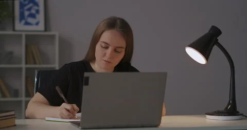 E-learning at home, female student is viewing lecture online and writing notes Stock Footage 147258581