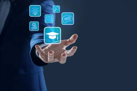 E-learning. Man showing different icons on virtual screen against dark back.. Stock Photos