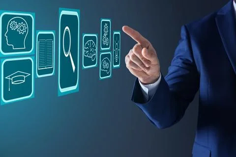 E-learning. Man using virtual screen with different icons on dark backgroun.. Stock Photos