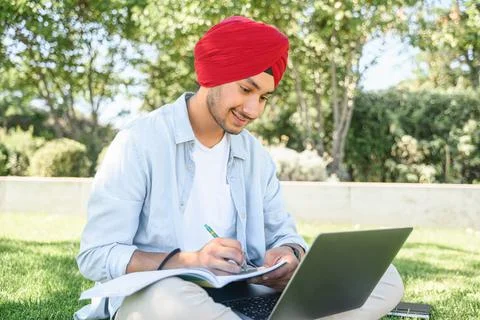 E-learning. Multiracial Indian man in turban using laptop for watching online Stock Photos