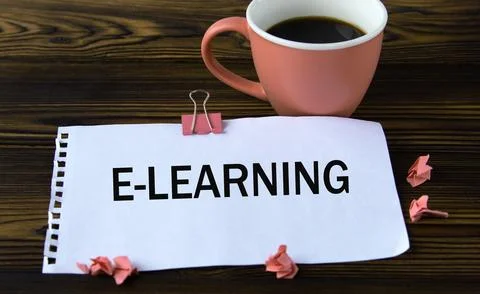 E-Learning - word on a white sheet on a wooden brown background with a cup of Stock Photos