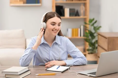 E-learning. Young woman using laptop during online lesson at table indoors Foto stock