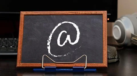 E-mail symbol on the background of the workplace in the office or at home. Stock Photos
