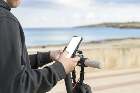 E-Mobility young man with electric scooter using smartphone app Stock Photos