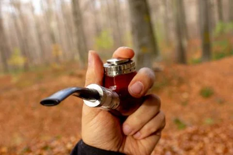 E-pipe with blurred background in man's left hand in natural ambient. Stock Photos
