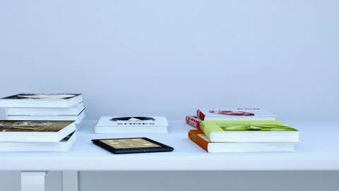 E-reader and books lying on a table, 3D Rendering 스톡 일러스트