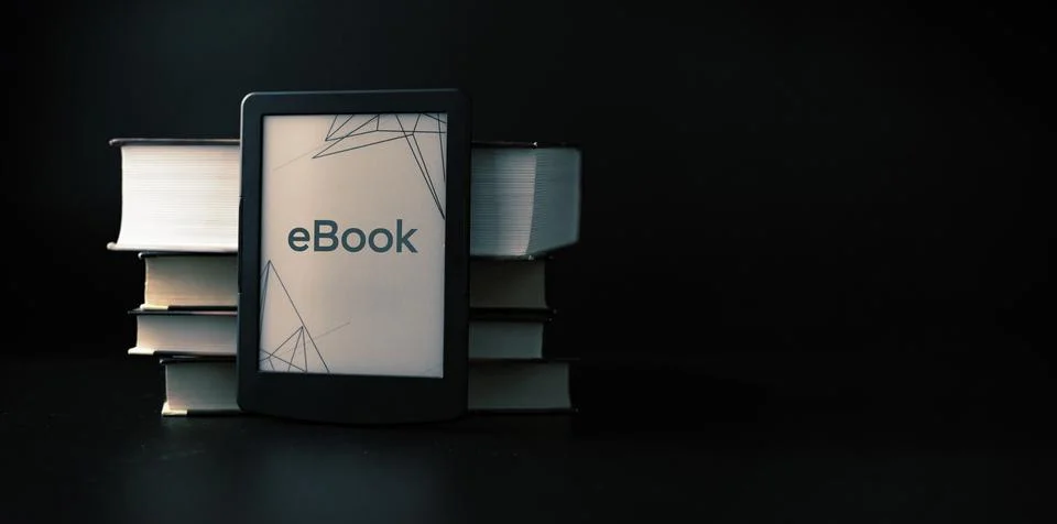 E reader. Digital e book, library reader tablet with books on dark background Stock Photos