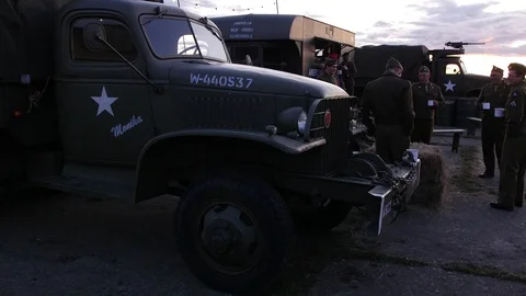 E S US 2nd world war soldiers have a drink next to vehicles slow motion 4K Stock Footage 116268176