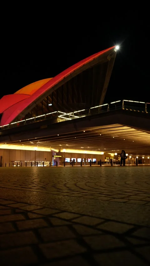 E Vertical jogger passes VIVID Sydney Opera House 6K Stock Footage 310394030