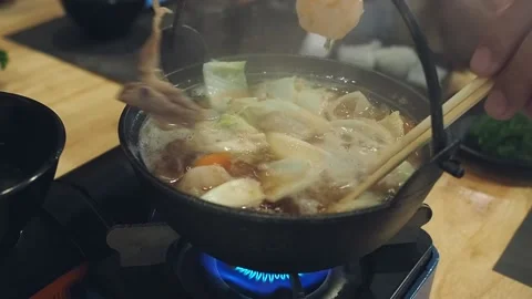 Each members of the dining table used chopsticks to grab food from Shabu pot. Stock Footage 157905523