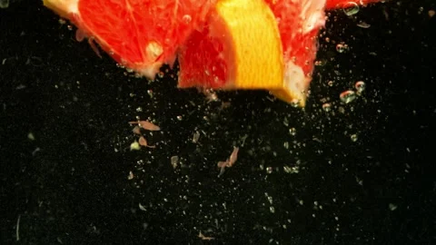 Each piece of grapefruit, falling into the water, reflects the rays of light. Video stock 265252922