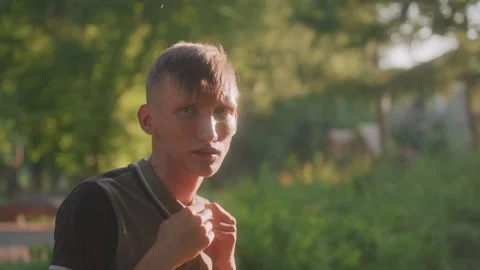 Eager Man Checks Surroundings While Walking Through Sunlit Park, Tense Man With 動画素材 329488568