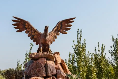 Eagle statue with spread wings on the mountain against the sky Stock Photos