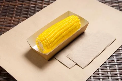 An ear of boiled corn in an eco-friendly cardboard box Stock Photos