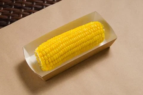 An ear of boiled corn in an eco-friendly cardboard box Stock Photos