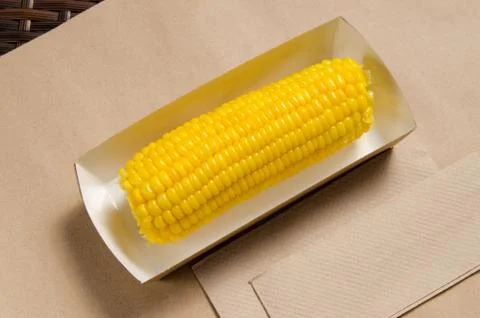 An ear of boiled corn in an eco-friendly cardboard box Stock Photos