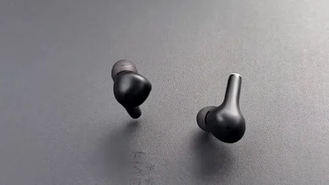 Ear buds dropping in slow motion on black 스톡 동영상 202612329