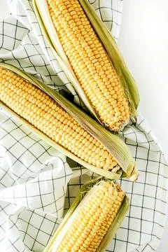 Ear of corn on white blanket. Flat lay, top view vegetarian food concept. Stock Photos