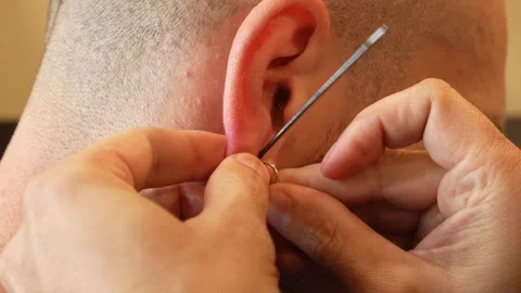 Ear piercing procedure for earring insertion, close-up Stock Footage 310845510