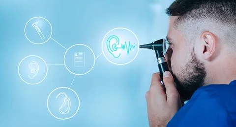 Ear treatment future technologies. Ear doctor with otoscope looking on sensor Stock Photos